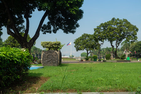 Rizal Park, Manila, Philippines July 2, 2014: The Philippine Flag framed by grasses and trees at the Rizal Park in Manila, Philippinesのeditorial素材