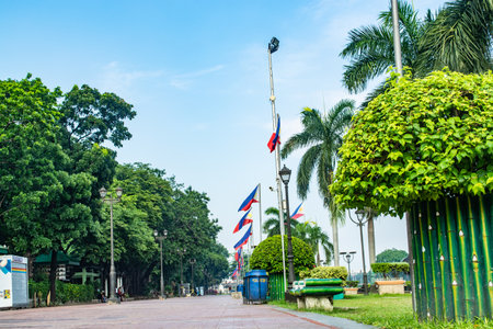Rizal Park, Manila, Philippines July 2, 2014: A pathway with a row of Philippine flags and trees at the Rizal Park along Taft Ave., Manila, Philippinesのeditorial素材