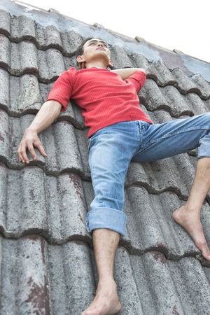 man lie down on the roof for inspirationの写真素材