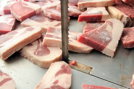 cut of meats in butcher on saw machineの写真素材
