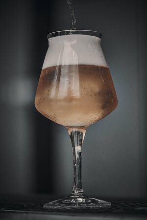 glass of beer while it is being filled, frontal view