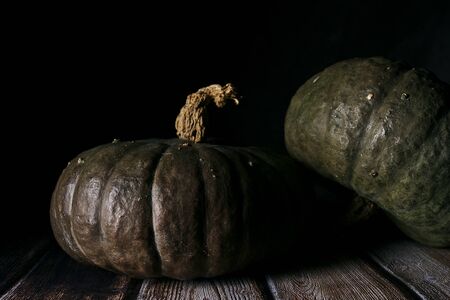 two pumpkins on wooden boardsの写真素材