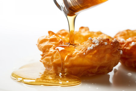 A person pouring syrup onto yakgwa, deep-fried pastry made with honey, sesame oil, and ginger juice on a plate. AI generative.の素材