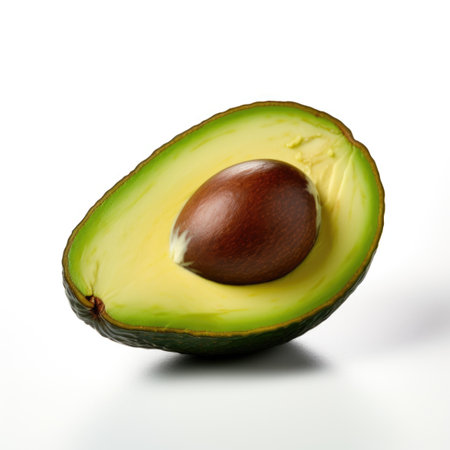 An avocado cut in half on a white surface.の素材
