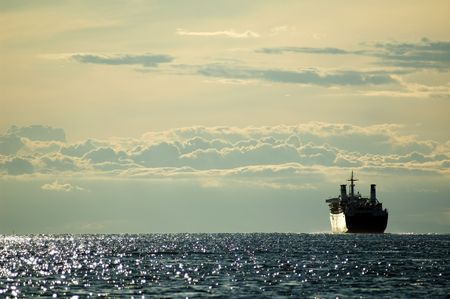 Huge boat sailing in the late afternoon sea with cloudy sky in the backgroundの写真素材