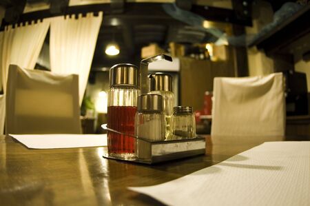 Table in a hotel / restaurant with napkins, salt, pepper, vinegar and oil