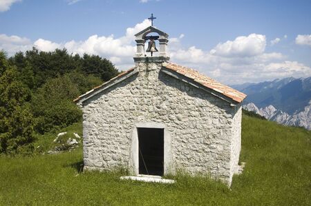 Small church high in the mountains placed on the meadowの写真素材