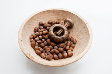 Wooden bowl filled with hazelnuts, walnuts and nut crasher.の写真素材