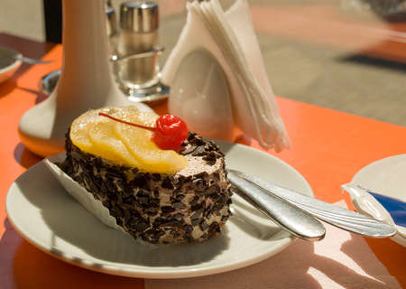 Chocolate cake with a cherry and pineapple