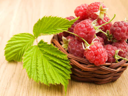 Raspberries in the basket on the table