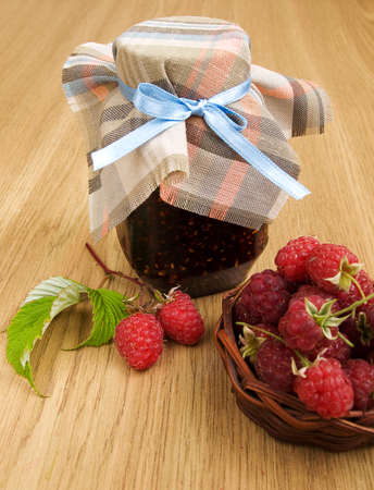 Raspberry jam and fresh raspberries on the table