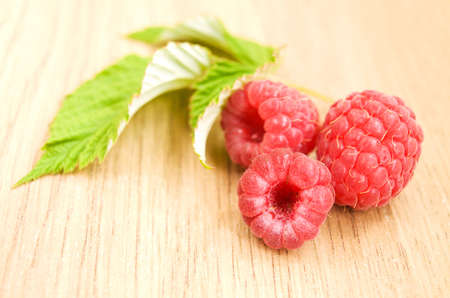 Fresh raspberries with leaves on the table