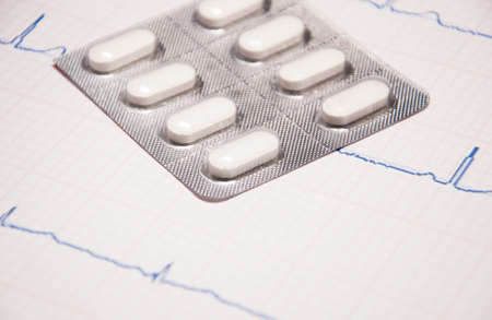 Close up of a EKG with pills sitting on top of itの写真素材
