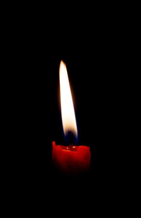 Single candle with  flame on black backgroundの写真素材