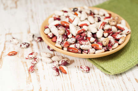 Bowl with haricot bean on a wooden background