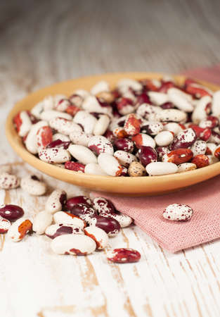 Bowl with haricot bean on a wooden background
