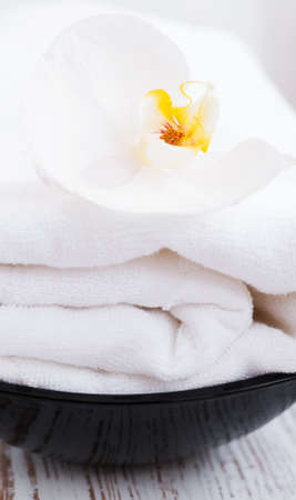 White Orchid flower and white towel on a wood backgroundの写真素材