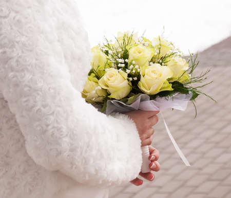 A bride holds her bouquet of  rosesの写真素材