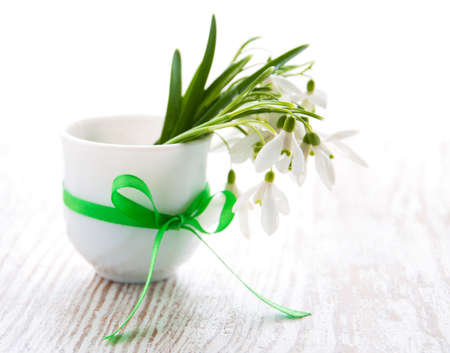 Bouquet of snowdrop flowers in  vase, on a old wooden backgroundの写真素材