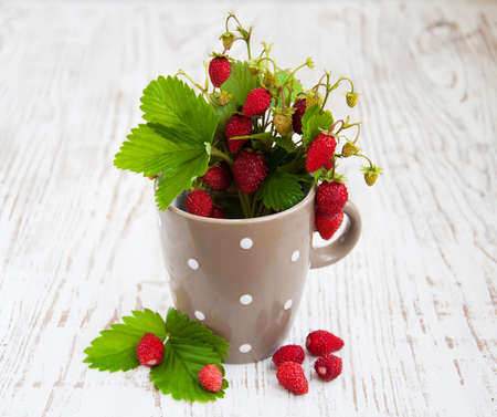 Cup with wild strawberry on a wooden backgroundの写真素材