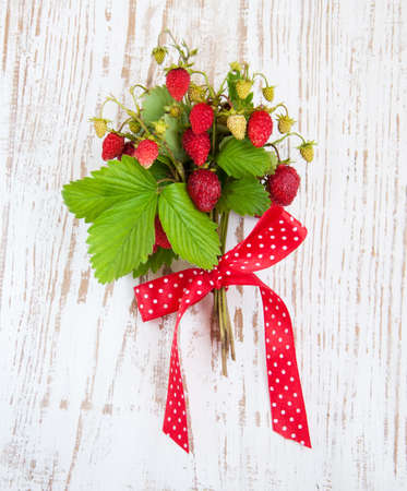 bunch of  wild strawberry on a wooden backgroundの写真素材