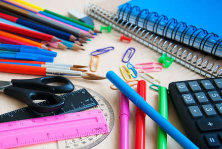 notebook with pencils, calculator and various school or office supplies.
