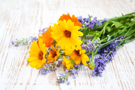 bouquet of calendula and lavender  flowers on a wooden backgroundの写真素材