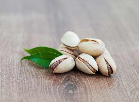 Pistachios with leaves on a wooden backgroundの写真素材