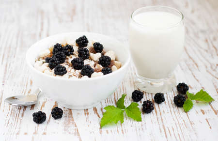 Bowl of muesli cereal with  blackberries on a wooden backgroundの写真素材