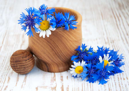 Mortar and pestle with cornflowers on a wooden backgroundの写真素材