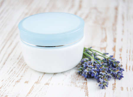 container with cream  and lavender on white wooden backgroundの写真素材