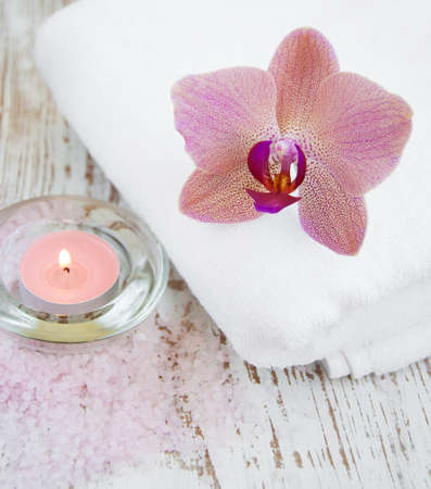 Orchids, towel and candle on a wooden backgroundの写真素材