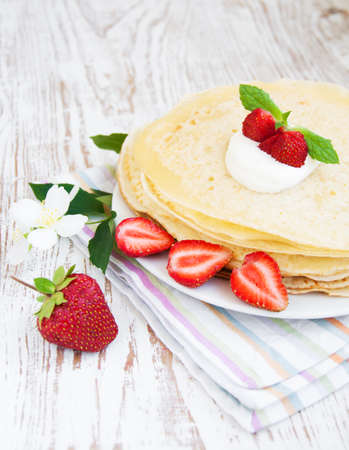 Stack of pancakes with strawberries and whipped creamの写真素材