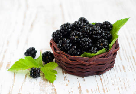 Basket of Ripe fresh organic blackberry on a wooden  background