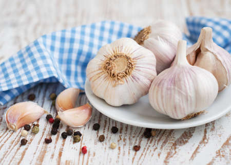 Garlic with peppercorns on a wooden backgroundの写真素材