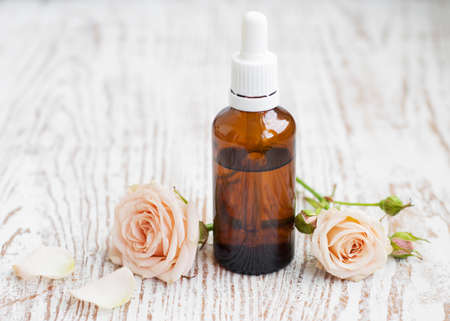 Bottle of essential oil and pink rosesの写真素材