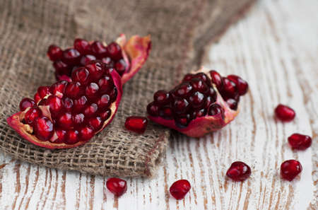 Burlap sack with Open pomegranate  on wooden backgroundの写真素材