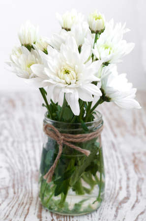 Vase with white chrysanthemum on a wooden backgroundの写真素材