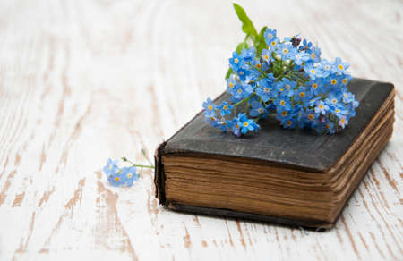Bunch of forget-me-nots flowers and very old bookの写真素材