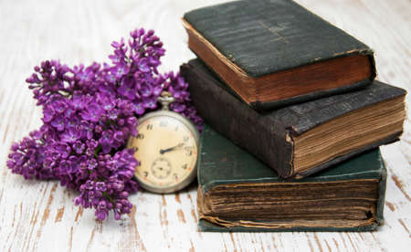 Old Books  and lilac branch on a wooden backgroundの写真素材