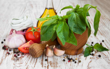 Fresh ingredients for cooking: pasta, tomato and spices over wooden tableの写真素材