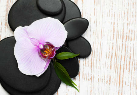 Spa stones, orchid flower heads on a wooden  backgroundの写真素材