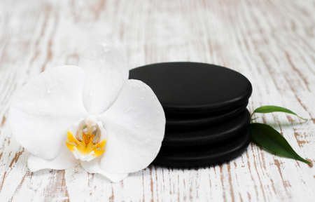 Spa stones, orchid flower heads on a wooden  backgroundの写真素材
