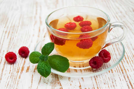 Cup of tea with raspberry  and some fresh raspberries
