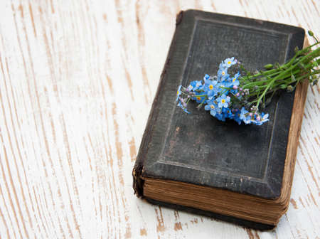 Bunch of forget-me-nots flowers and very old bookの写真素材