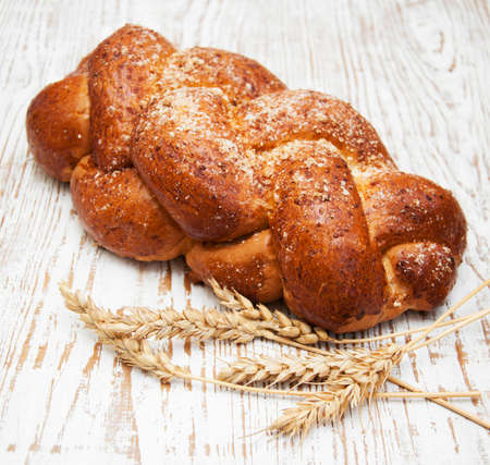 Bread and wheat on a wooden background