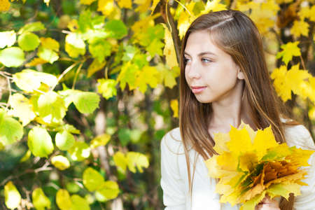 Portrait of very beautiful young girl in autumn parkの写真素材