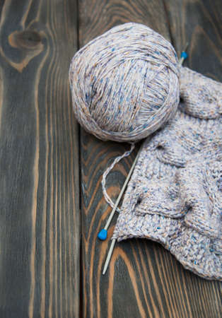 knitting and needles on rustic wooden background