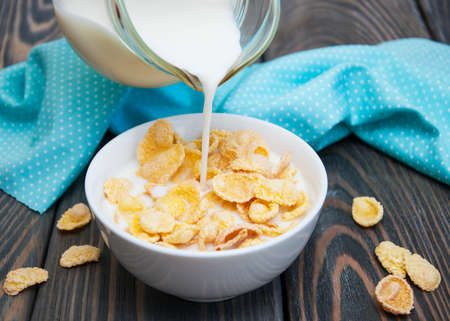 milk being poured over a bowl full of  cereal