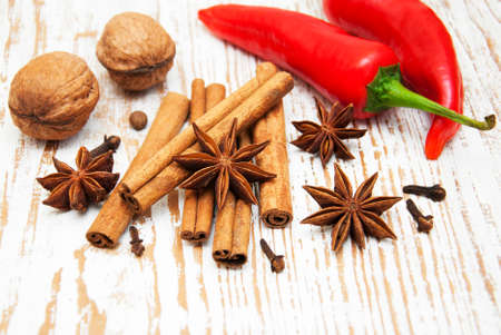 Star anis,  cinnamon stick, walnut and cloves on a wooden backgroundの写真素材